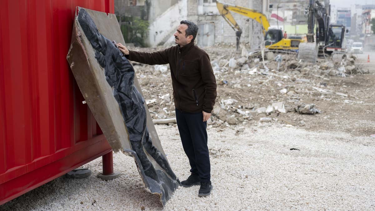 Enkazdan çıkardığı Atatürk rölyefini dükkanının önünde sergiliyor