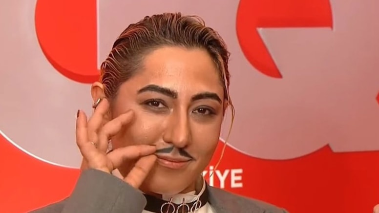 Ünlü şarkıcı geceye bıyıklı erkek kılığında katıldı