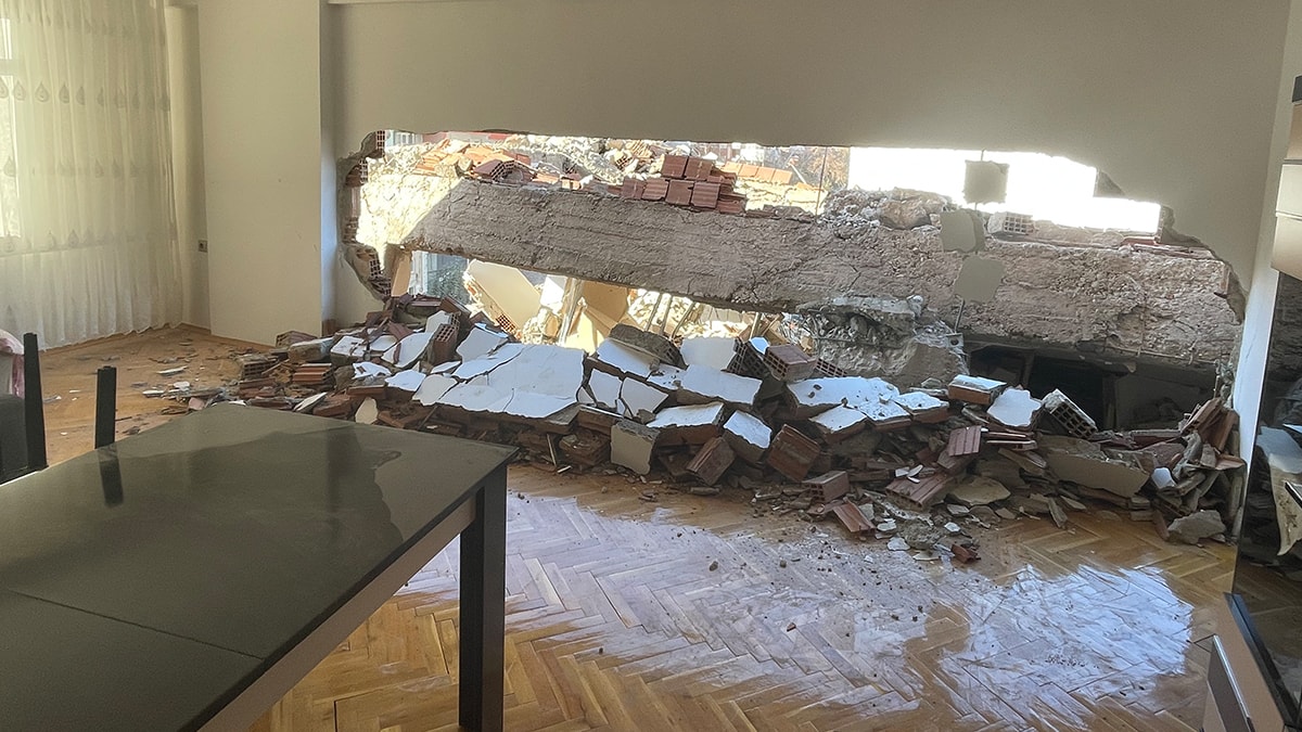 Hasarlı bina yıkımında sağlam eve kepçe