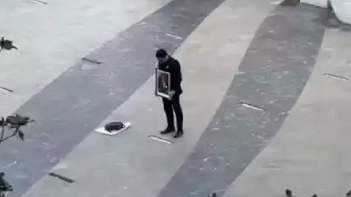 Elindeki Atatürk portresiyle saygı duruşuna geçti