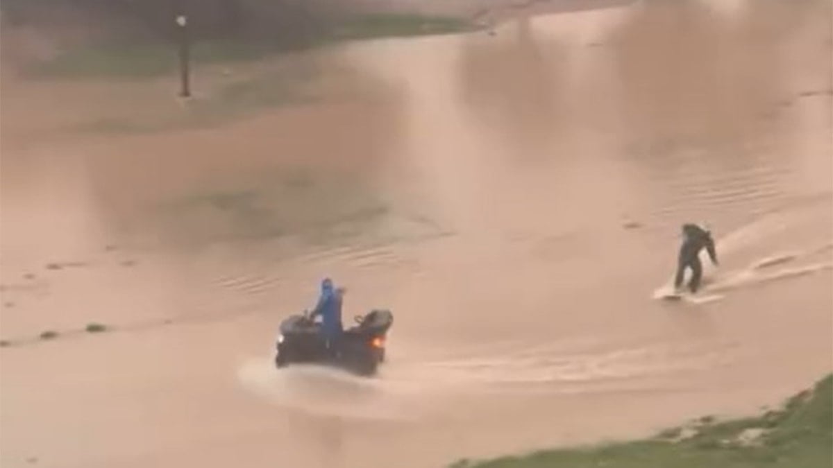 Sağanak sonrası caddede sörf yaptı