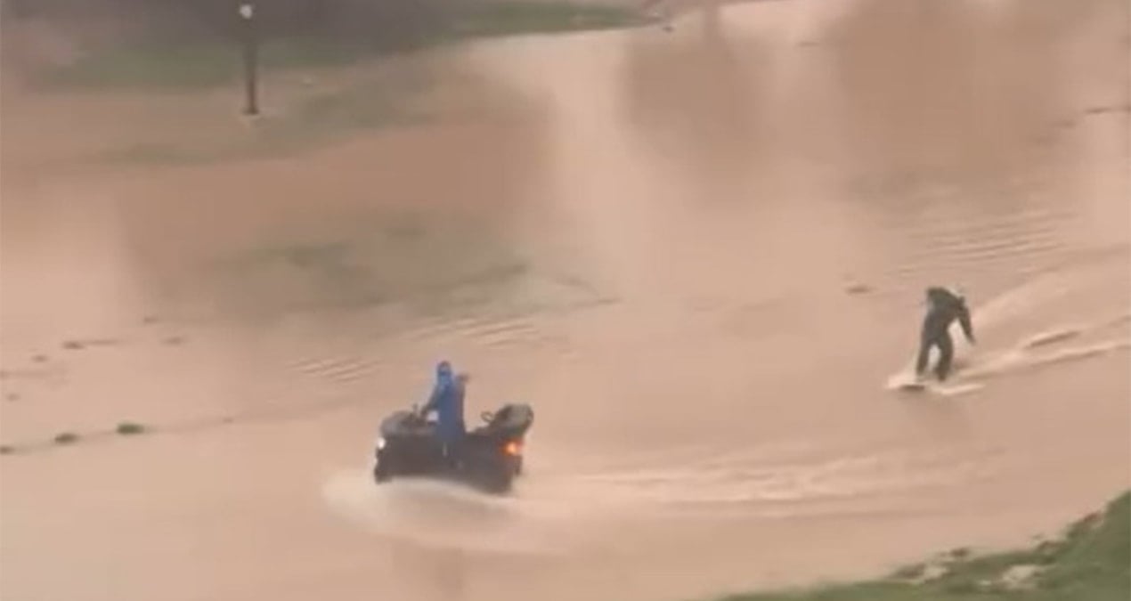 Sağanak sonrası caddede sörf yaptı