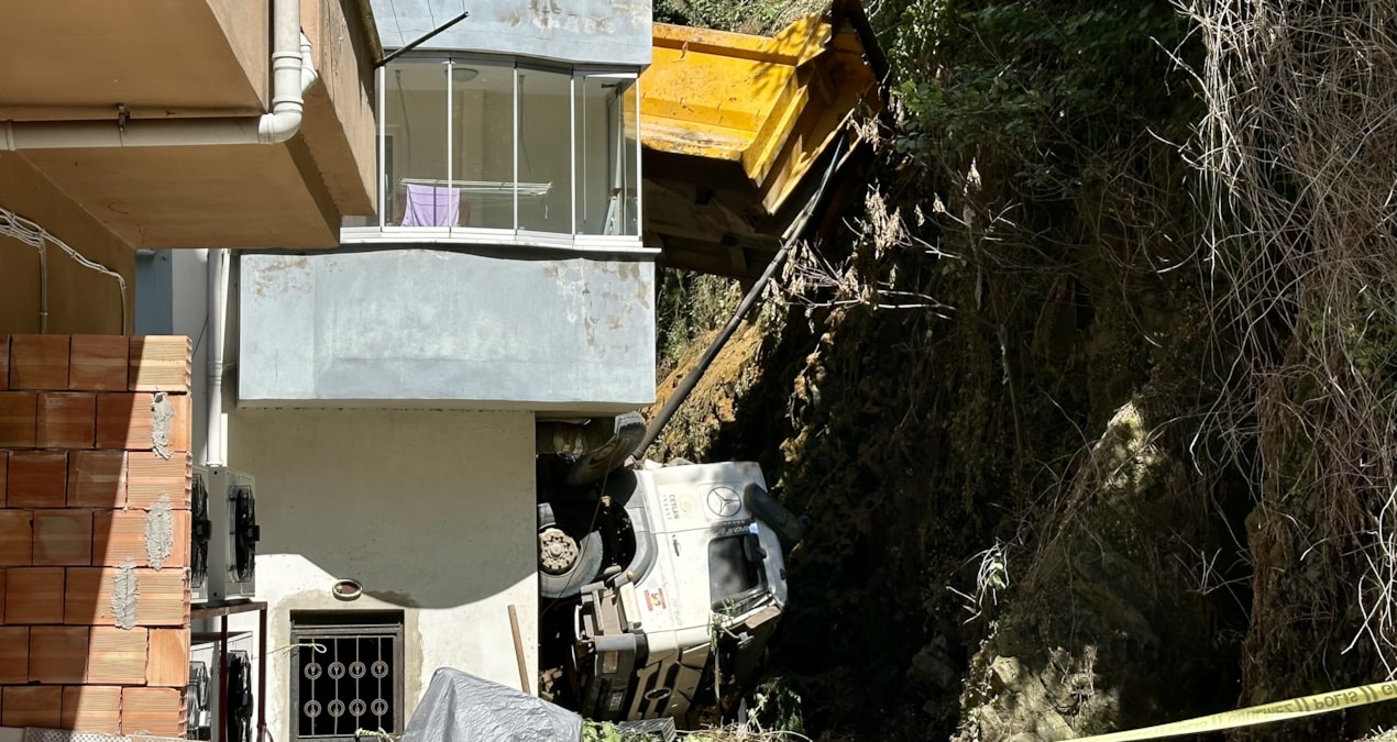 Kamyon istinat duvarından devrilip apartmana çarptı; 2 daire hasar aldı