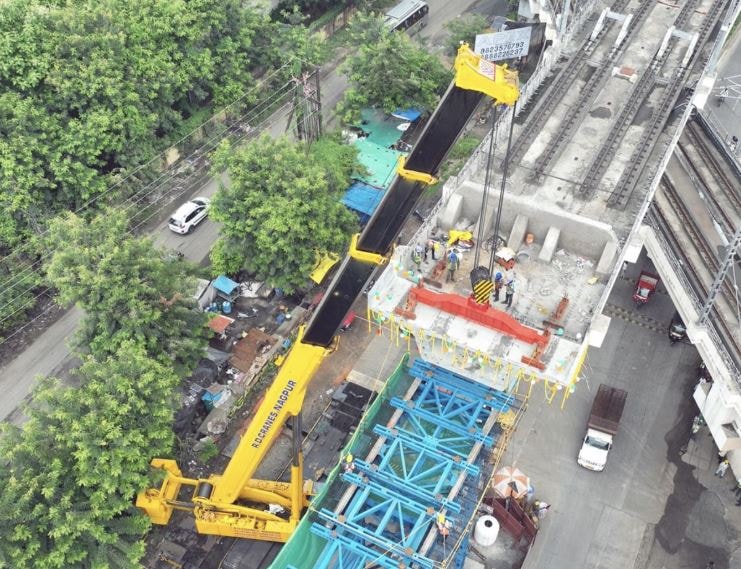 Hindistan’ın Nagpur kentinde, ulaşım altyapısını tamamen baştan yazacak devasa bir metro projesi için kelimenin tam anlamıyla "mühendislik harikası" bir lojistik operasyon yürütülüyor. Kent içi trafiğe nefes aldırması planlanan dev yatırım kapsamında, her biri tam 120 ton ağırlığında olan akılalmaz boyutlardaki beton kirişler şantiye alanlarına taşınıyor. Toplamda 140 adet dev yapının kullanılacağı projede, çalışmalar gece gündüz kesintisiz bir şekilde devam ediyor.  Saatte Sadece 10 Kilometre: 